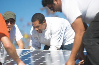 A group of men install solar panels